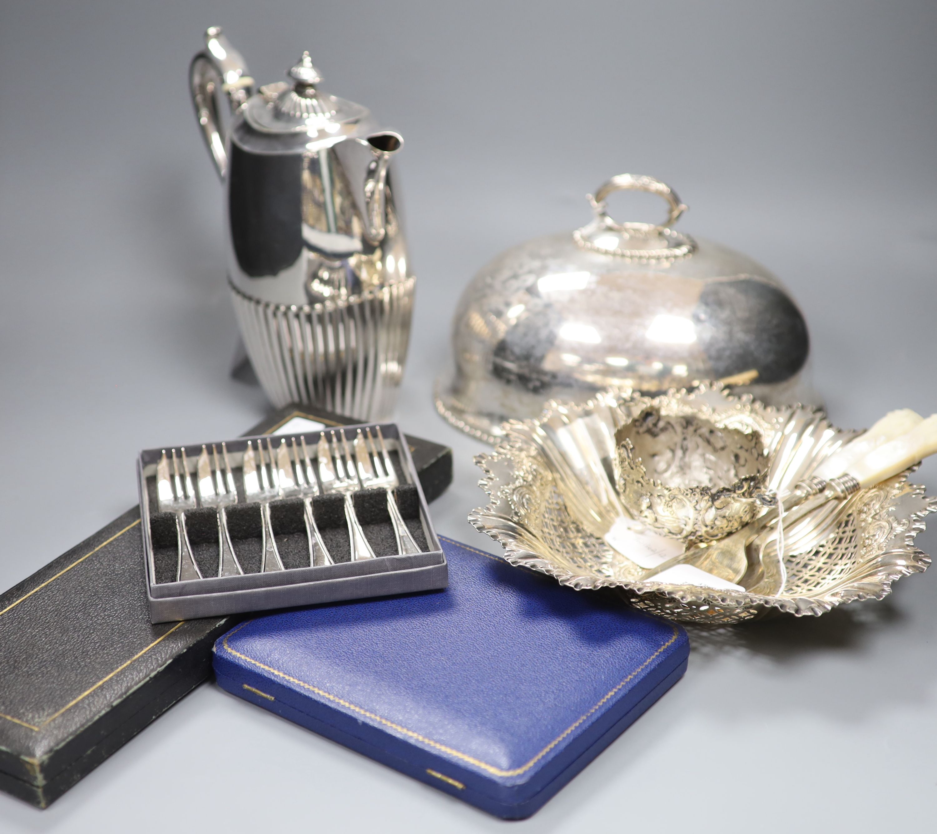 A cast white metal bowl and a collection of plated items, including a hot water pot, meat cover, cased flatware etc.